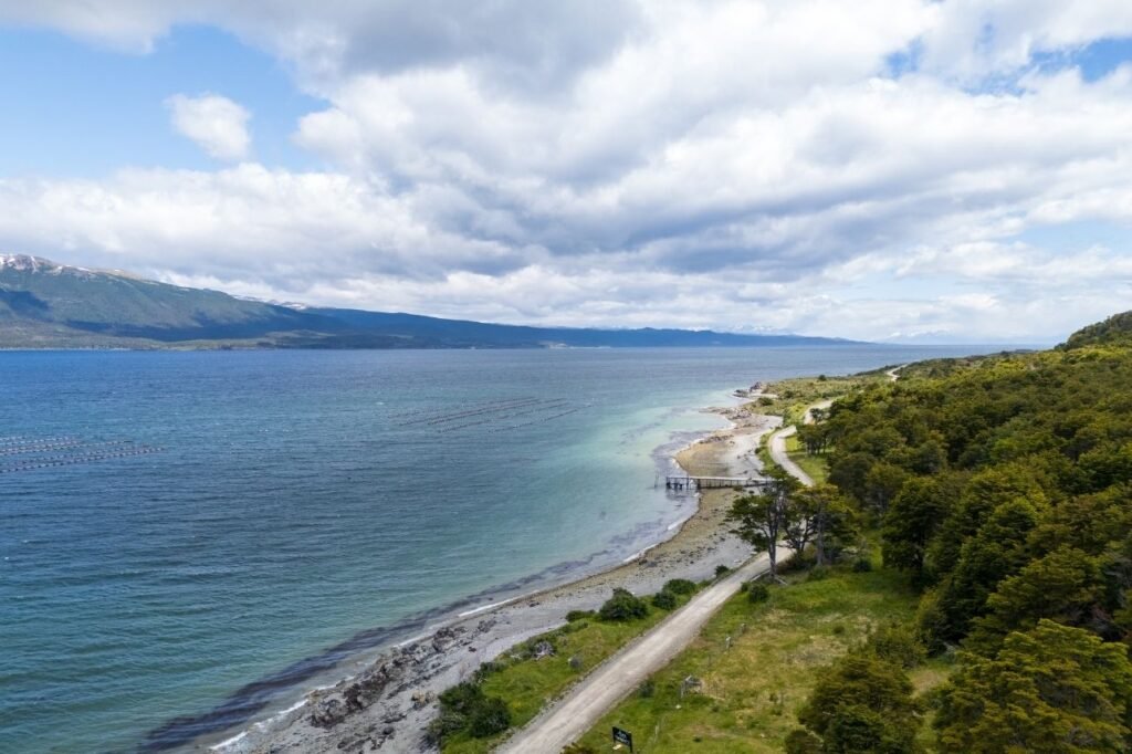 Costa de Puerto Almanza con el Canal Beagle, un muelle y cultivos de mejillones, vista aérea, Tierra del Fuego