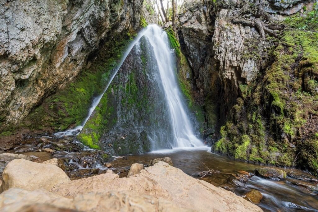 Primer plano de la Cascada del Duende en larga exposición, con efecto seda entre rocas y musgo, Tierra del Fuego