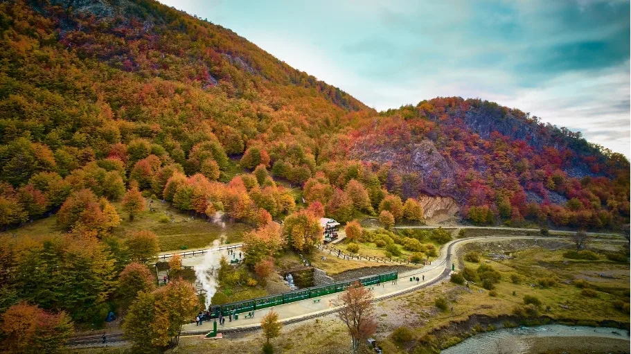 Vista aérea del Tren del Fin del Mundo recorriendo el valle del Río Pipo con bosques de otoño en Tierra del Fuego.