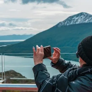 Una turista saca una foto con su celular al Lago Escondido desde el Mirador Paso Garibaldi en Ushuaia.