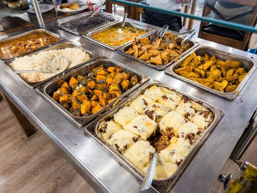 Bandejas de buffet gastronómico con pasteles, guisados, arroz, papas y carnes en Park Austral.