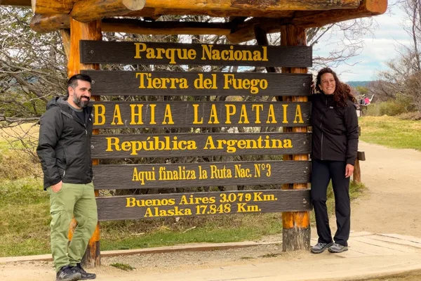 Cartel de madera en Bahía Lapataia, Parque Nacional Tierra del Fuego, que marca el final de la Ruta Nacional 3 en Argentina, con distancias a Buenos Aires y Alaska.