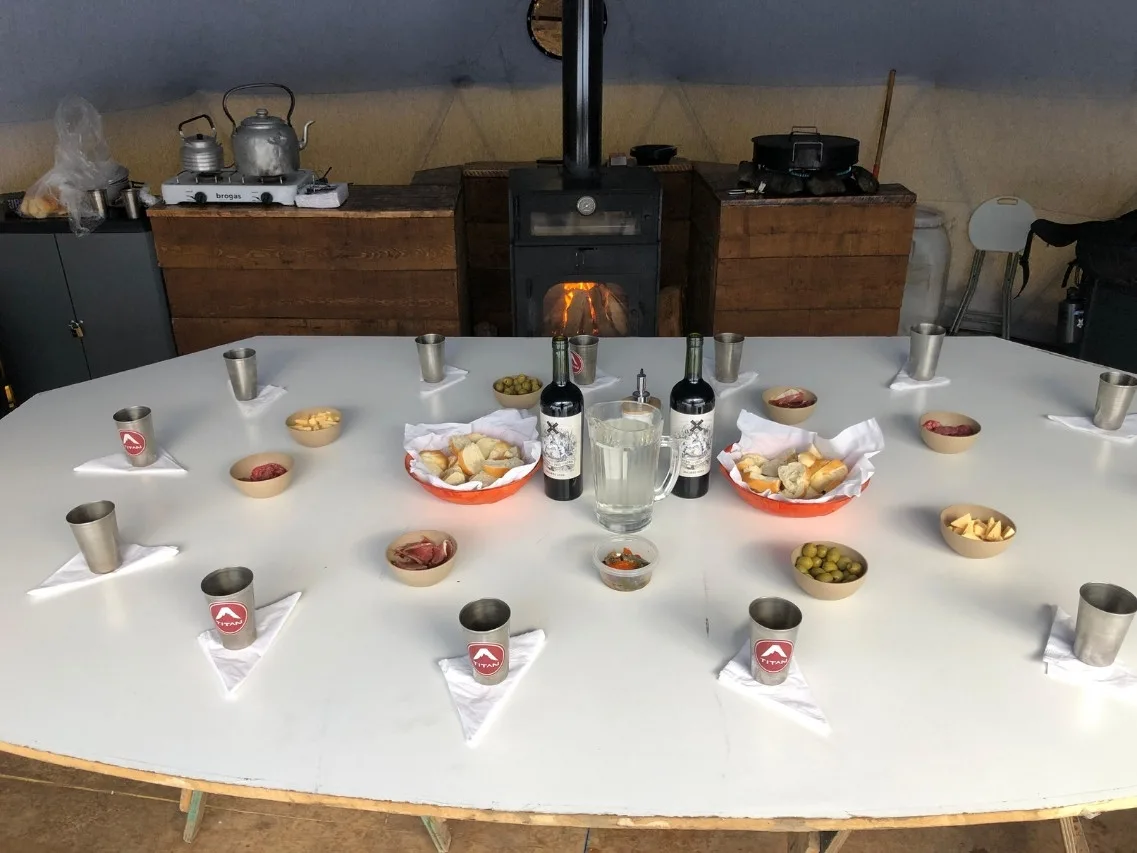 Domo de montaña calefaccionado con estufa a leña y mesa preparada con picada regional para el Trekking Laguna Esmeralda