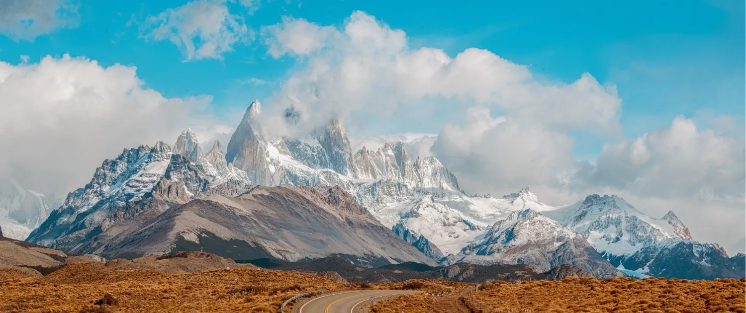 Vista del imponente Monte Fitz Roy con sus picos nevados bajo un cielo azul en El Chaltén.